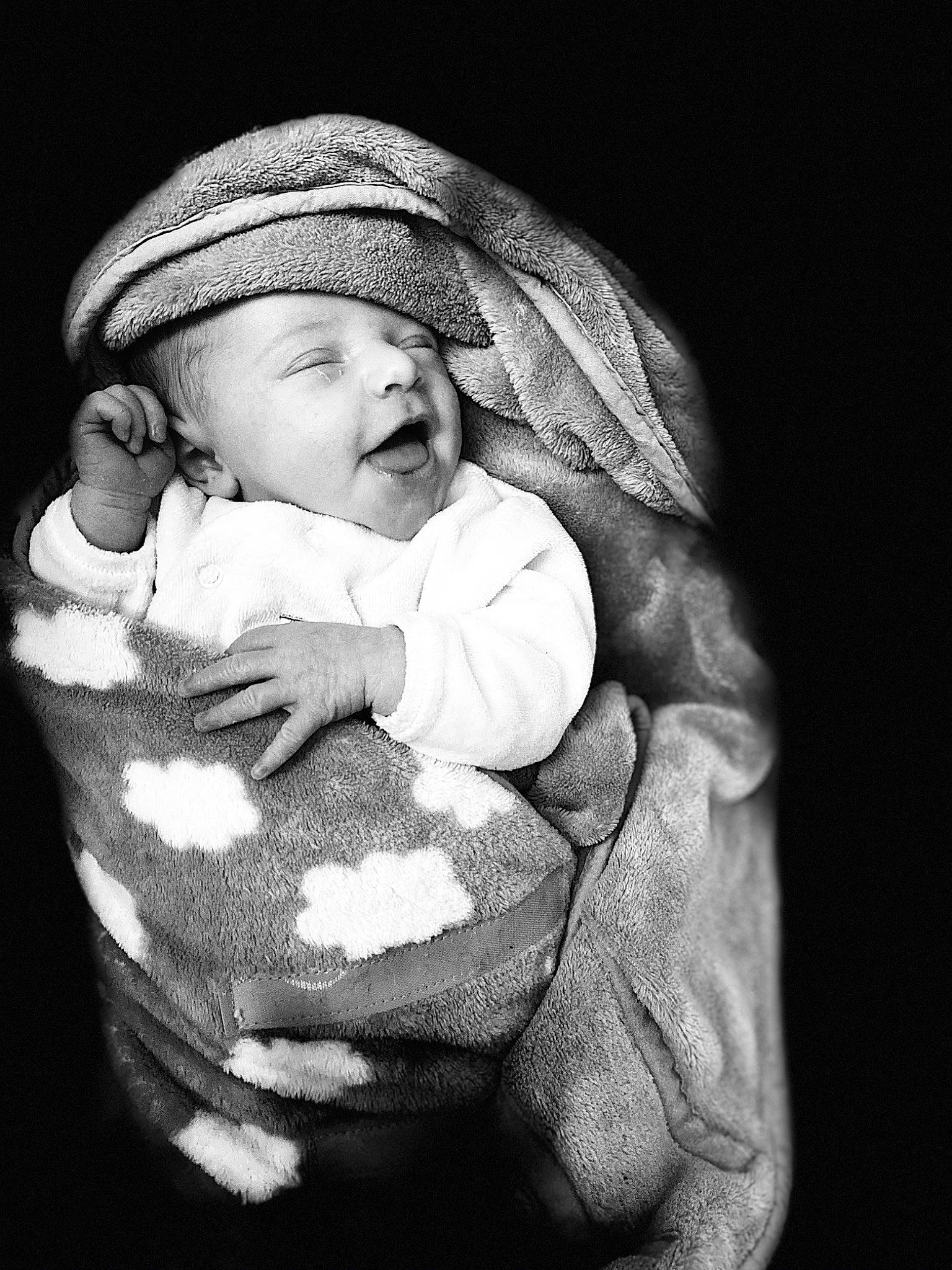 Apolline participe au concours pour gagner de l'argent avec cette photo : baby, baby_toddler_clothing, black_and_white, cap, cheek, child, comfort, darkness, finger, flash_photography, gesture, hand, happy, headgear, headwear, monochrome, monochrome_photography, mouth, outerwear, person