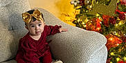 Ayla joined the competition — help win amazing prizes! baby, celebration, child, christmas_tree, couch, cozy, decorations, festive, floor, golden_bow, happy, holiday_decor, indoors, lighting, ornaments, person, presents, red_dress, seated, smiling