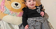 Alany joined the competition — help win amazing prizes! baby, black_clothing, blanket, bow, crib, cushion, dress, earrings, happy, headband, houndstooth_pattern, indoor, infant, nursery, plush_lion, portrait, sitting, smiling_baby, soft_toy, stuffed_animal