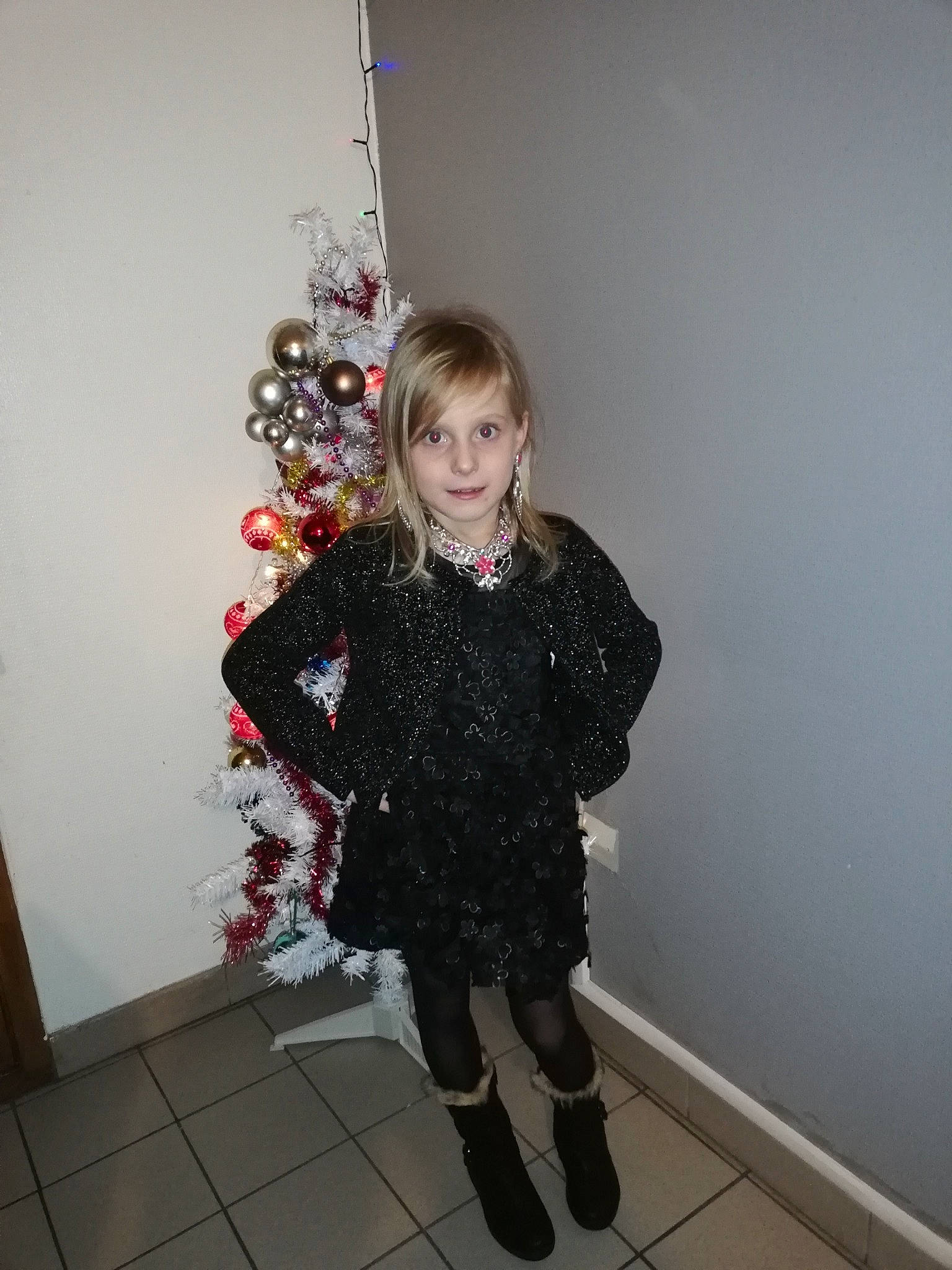 Inaya participe au concours pour gagner de l'argent avec cette photo : black, child, clothing, costume, design, dress, fashion_accessory, fun, girl, human_body, outerwear, pattern, person, red, shoulder, smile, snapshot, standing, textile, top