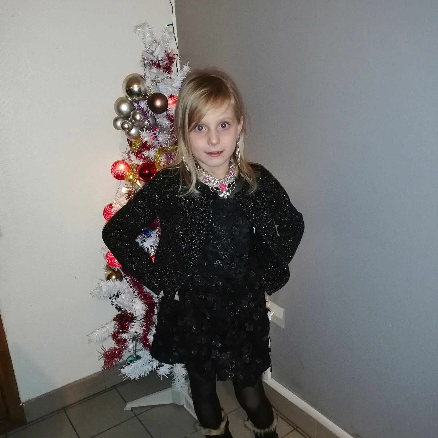 Inaya participe au concours pour gagner de l'argent avec cette photo : black, child, clothing, costume, design, dress, fashion_accessory, fun, girl, human_body, outerwear, pattern, person, red, shoulder, smile, snapshot, standing, textile, top