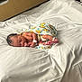 Defranko is registered to the contest to win money with this photo: adult, architecture, baby, bed, blanket, building, childbirth, clothing, face, furniture, head, hospital, indoors, male, man, newborn, person, photography, portrait, sleeping