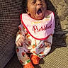 Knoréal joined the competition — help win amazing prizes! baby, bib, child, couch, cute, face, footwear, happy, home, indoors, infant, onesie, orange_socks, person, pink_bib, seated, soft_lighting, strawberry_pattern, text_on_bib, yawning
