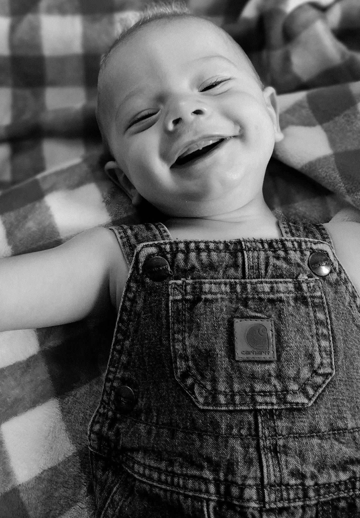 Tegan is registered to the contest to win money with this photo: arm, baby_toddler_clothing, black, cheek, eye, face, facial_expression, flash_photography, hairstyle, hand, head, human, human_body, lip, organ, person, photograph, product, skin, smile