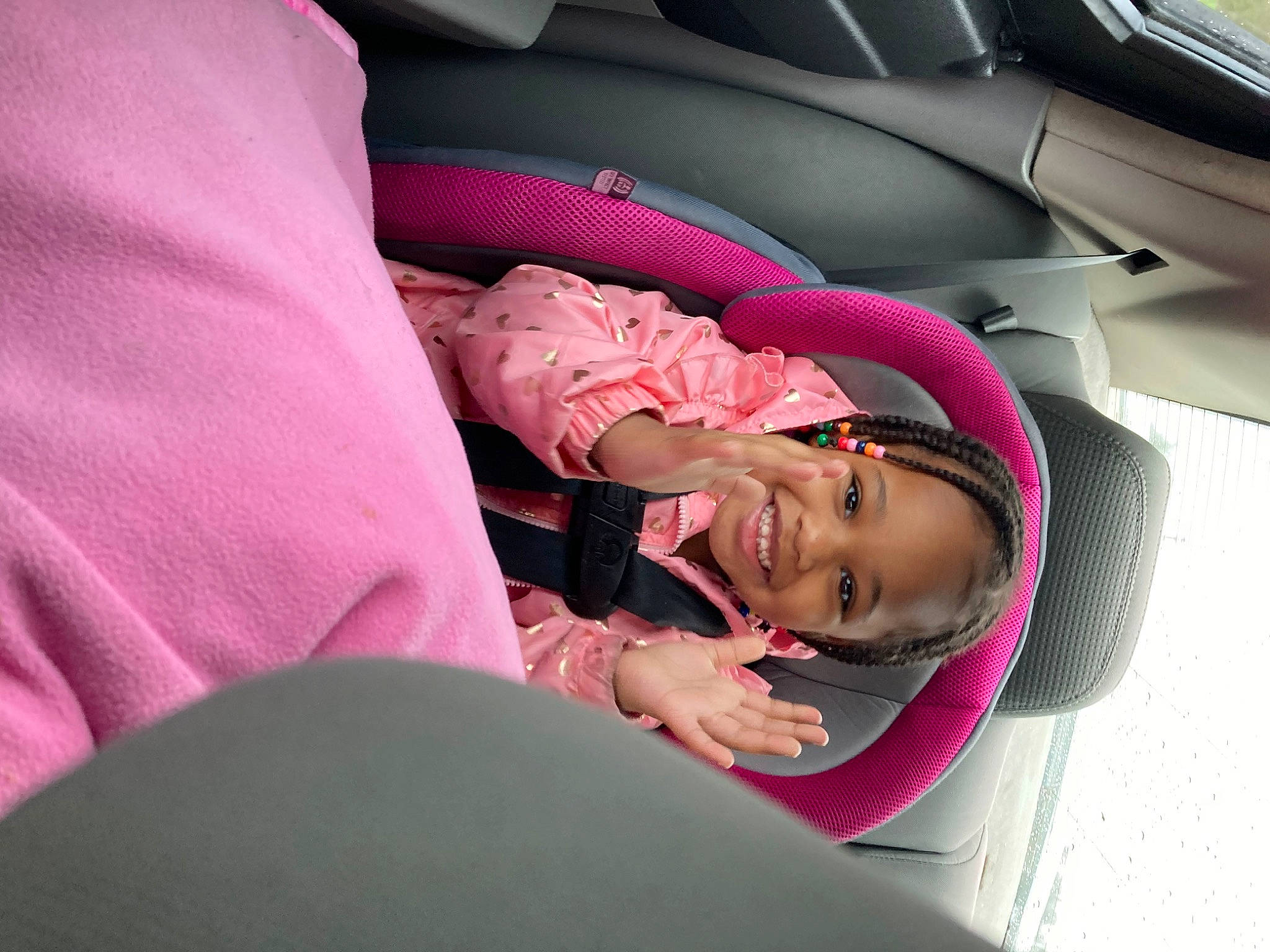 Arya is registered to the contest to win money with this photo: auto_part, automotive_design, baby, baby_in_car_seat, car, car_seat, car_seat_cover, child, comfort, finger, head_restraint, joy, magenta, mammal, motor_vehicle, person, pink, seat_belt, smile, steering_wheel