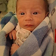 Jackie is registered to the contest to win money with this photo: baby, bed, blanket, blue, checkered, clothing, cozy, cute, expression, face, indoors, infant, newborn, person, portrait, resting, sleepwear, small_hands, white, wrapped