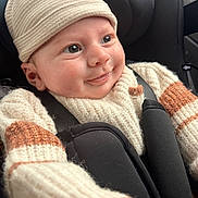 Lucas participe au concours pour gagner de l'argent avec cette photo : baby, infant, child, car_seat, seatbelt, sweater, knit_hat, drool, smile, cheeks, eyes, portrait, close_up, cozy, warm_clothing, car_interior, buckle, adorable, headwear, young
