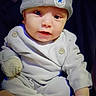 baby, infant, child, portrait, face, eyes, looking_at_camera, hat, knit_hat, star, winter_clothing, sweater, mittens, white_clothing, sitting, indoor, close_up, person, cozy, photography