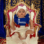 Kylie is registered to the contest to win money with this photo: baby, child, throne, royalty, princess, blue_outfit, white_bow, red_bows, knee_high_socks, diaper, gold_decoration, velvet_curtains, carpet, serious_expression, indoor, portrait, cute, adorable, sitting, person
