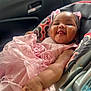 Serenity is registered to the contest to win money with this photo: baby, child, pink_dress, car_seat, smiling, tongue_out, cute, infant, happy, patterned, seat, clothing, indoors, person, portrait, closeup, cheeks, hand, fabric, accessory