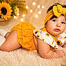 baby, child, infant, portrait, sunflower, yellow, bow, headband, dress, outfit, rug, teddy_bear, flowers, indoor, lying_down, smiling, face, soft_lighting, bokeh, photography