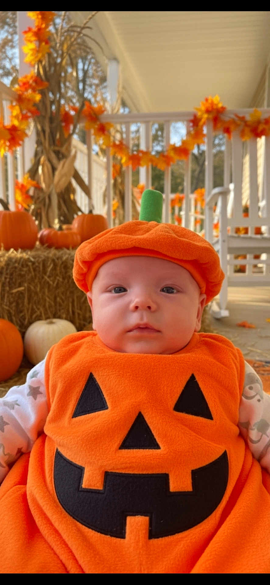 Camden is registered to the contest to win money with this photo: baby, pumpkin_costume, orange, fall, autumn, porch, decorations, pumpkin, hay, cute, child, face, costume, seasonal, holiday, outdoor, smile, festive, holiday_decoration, cozy