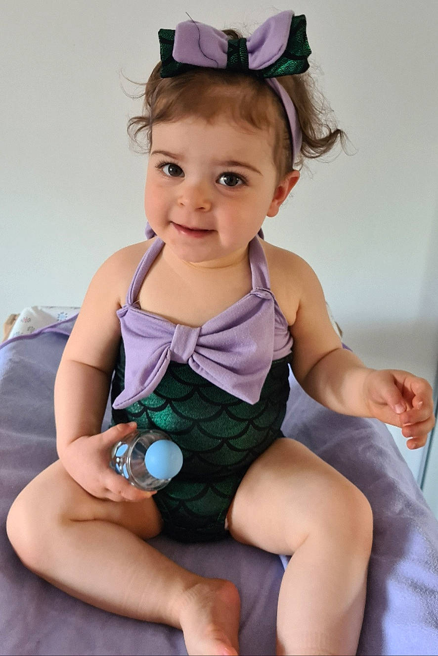 Iliana participe au concours pour gagner de l'argent avec cette photo : baby, baby_toddler_clothing, child, child_model, costume, fashion_accessory, hair_accessory, headband, headgear, joy, person, photography, purple, sitting, toddler