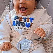 Maylan participe au concours pour gagner de l'argent avec cette photo : baby, infant, child, smiling, happy, curly_hair, baby_seat, safety_harness, clothing, cute, indoors, person, portrait, cozy, seat, straps, expression, face, small_hands, comfortable