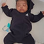 Maylan a rejoint le concours — aidez-le/la à gagner de superbes lots ! adorable, baby, black_clothing, blanket, child, cute, face, feet, hands, hood, indoors, infant, onesie, pacifier, peaceful, relaxed, resting, sleeping, soft_surface, young