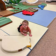Ronan is registered to the contest to win money with this photo: toddler, child, indoor_play_area, play_mats, soft_play, colorful_wall_mural, flower_mural, crawling, curious, padded_floor, toy_shapes, casual_clothing, short_hair, carpet, door, wall, playground, baby, floor, safe_environment