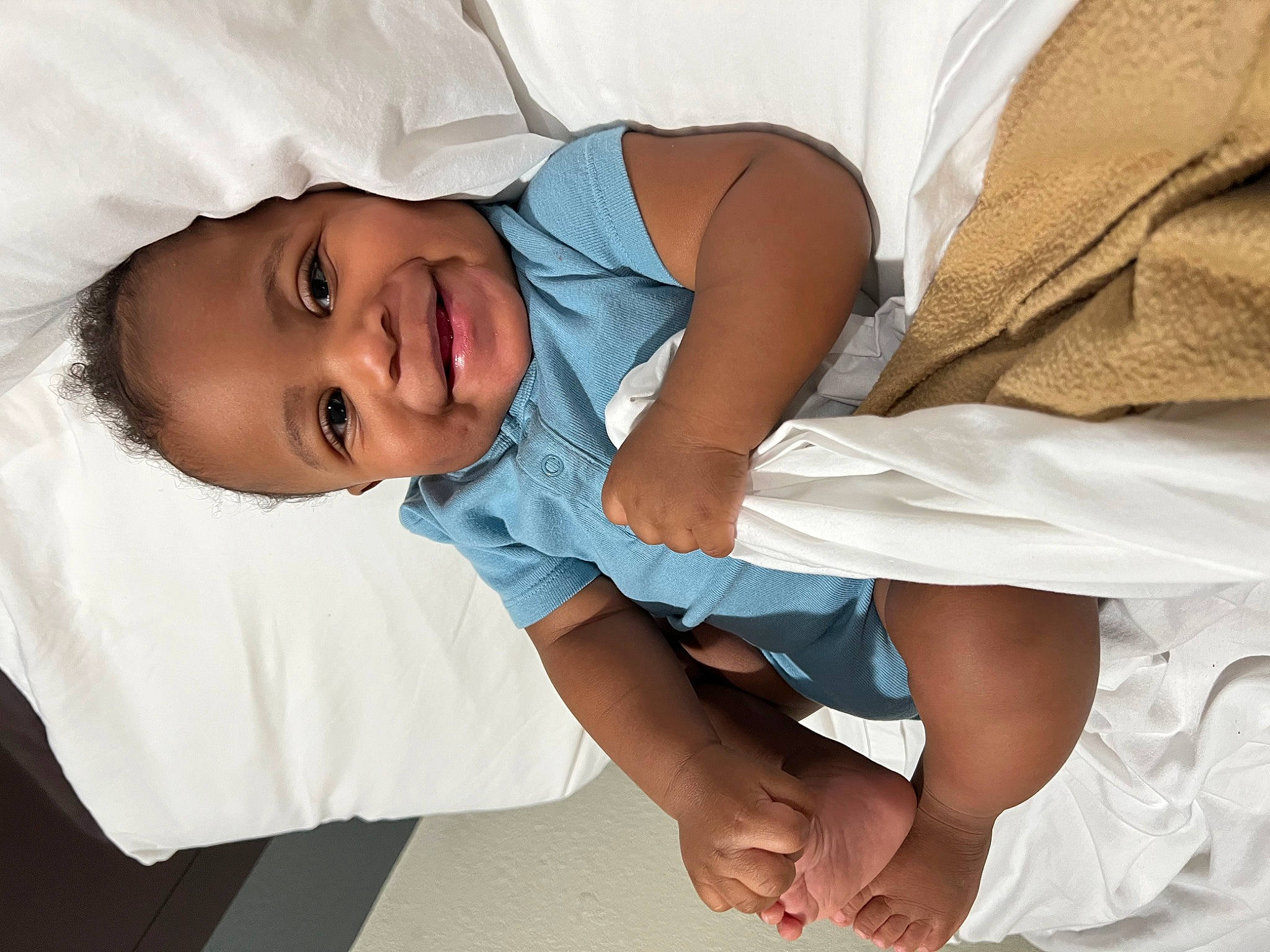 Javion is registered to the contest to win money with this photo: baby, baby_toddler_clothing, child, comfort, elbow, event, eye, finger, gesture, hand, happy, human_body, human_leg, joint, joy, linens, person, skin, sleeve, smile