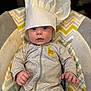 Matthew is registered to the contest to win money with this photo: baby, infant, child, chef_hat, onesie, striped_clothing, giraffe_patch, seat, patterned_cushion, indoor, portrait, cute, wide_eyes, small_hands, soft_lighting, closeup, adorable, expression, headwear, baby_girl_or_boy