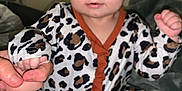 Aspyn joined the competition — help win amazing prizes! baby, infant, onesie, leopard_print, headband, bow, hand_holding, blanket, foot, sitting, indoors, person, child, cute, wide_eyes, clothing, soft_texture, portrait, baby_girl, support
