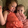 Aspyn is registered to the contest to win money with this photo: child, baby, couch, sitting, smile, face, happy, clothing, pink, orange, person, indoor, family, sibling, cute, portrait, toddler, infant, cozy, hug