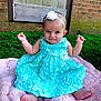 baby, child, dress, headband, flower, blue_dress, pink_blanket, grass, outdoor, brick_wall, happy, smile, barefoot, sitting, cute, infant, person, portrait, head, fingers