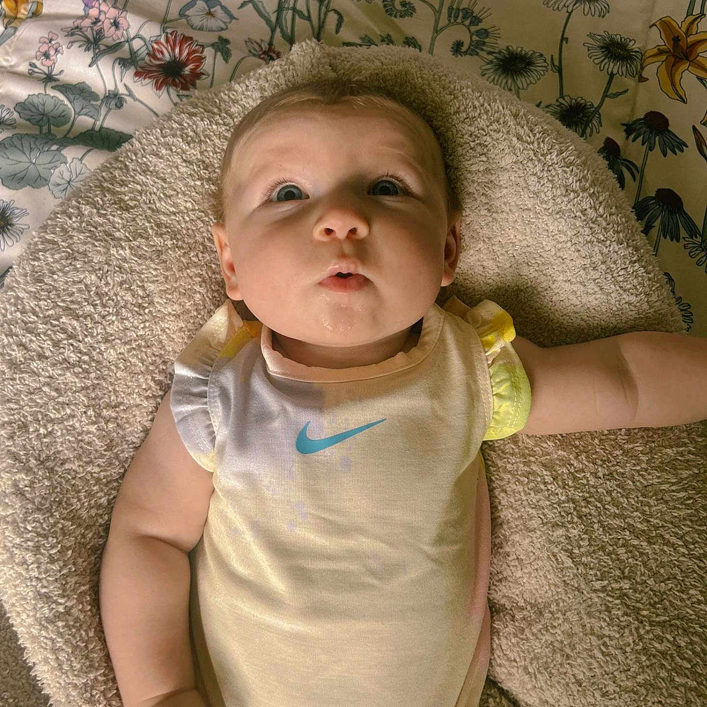 Afreya joined the competition — help win amazing prizes! baby, blanket, child, clothing, curious, expression, face, floral, hand, head, indoor, infant, light, looking_up, onesie, pattern, person, skin, soft_texture, young