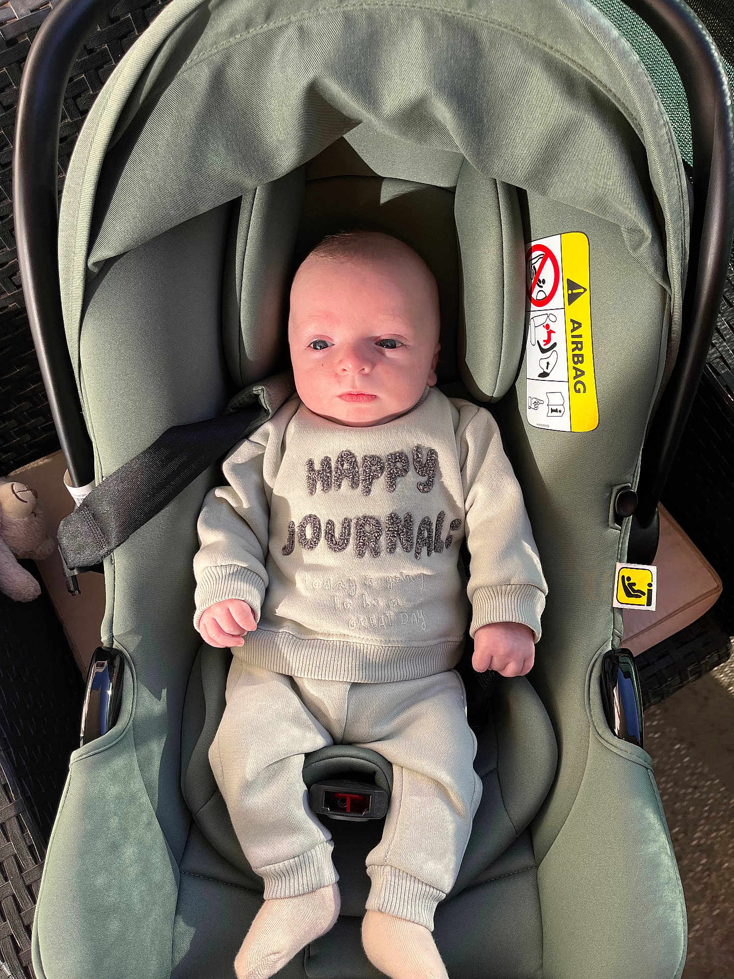 Louis participe au concours pour gagner de l'argent avec cette photo : baby, infant, car_seat, clothing, socks, face, person, seatbelt, green, plush_toy, sunlight, cozy, cute, child, newborn, sitting, indoors, soft, casual, portrait