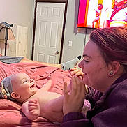 Margueritte joined the competition — help win amazing prizes! adult, baby, bed, blanket, clothing, door, earrings, hand, happy, hat, headband, indoor, interaction, lamp, laugh, person, room, screen, smile, television