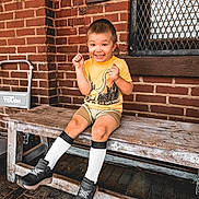 Asher is registered to the contest to win money with this photo: brick, clothing, cream, dessert, face, food, footwear, happy, head, hosiery, icecream, pants, person, photography, portrait, shoe, shorts, sitting, smile, sock
