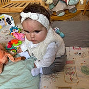 Alba participe au concours pour gagner de l'argent avec cette photo : baby, headband, white_clothing, vest, plush_toy, rocking_dog, play_mat, toy, floor, wooden_furniture, infant, child, socks, indoor, crawling, cute, colorful, patterned_pants, soft_toys, expression