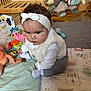 baby, headband, white_clothing, vest, plush_toy, rocking_dog, play_mat, toy, floor, wooden_furniture, infant, child, socks, indoor, crawling, cute, colorful, patterned_pants, soft_toys, expression