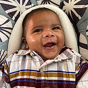 Samuel participe au concours pour gagner de l'argent avec cette photo : baby, smiling, plaid_shirt, cushion, patterned_background, happy, infant, closeup, portrait, child, cozy, buttoned_shirt, indoor, cute, face, person, young_child, head, expressive, cheerful