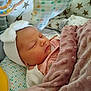 Romy participe au concours pour gagner de l'argent avec cette photo : baby, sleeping, blanket, headband, bow, cushion, patterned, soft, toy, infant, cozy, pink, white, clothing, face, peaceful, rest, indoor, portrait, child