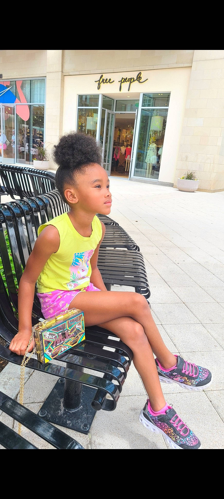 August is registered to the contest to win money with this photo: black, child, city, cool, fashion, hairstyle, happy, human_leg, human_settlement, leisure, people, person, public_space, road, sandal, sidewalk, standing, summer, thigh, toddler