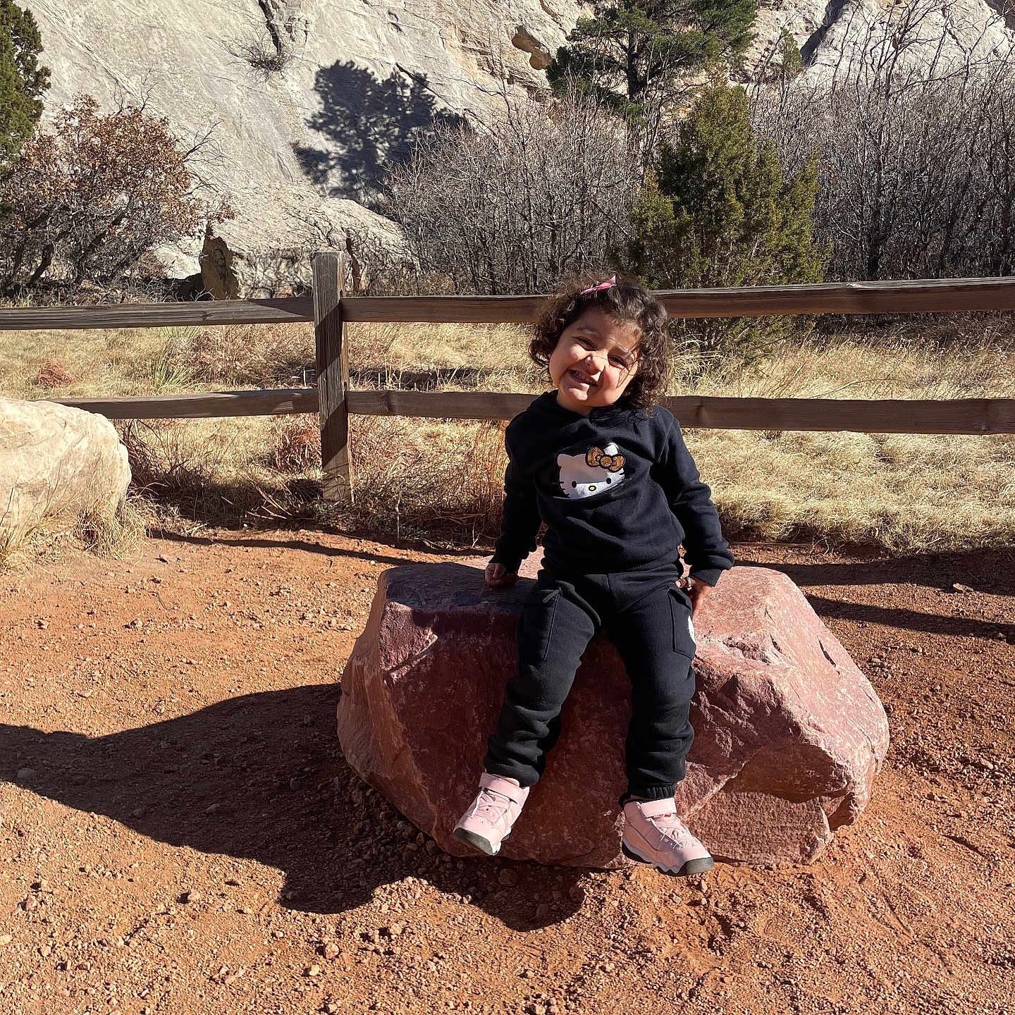 Layla joined the competition — help win amazing prizes! child, clothing, face, female, footwear, head, nature, outdoors, pants, person, photography, plant, portrait, rock, shoe, sitting, slate, soil, tree, wilderness