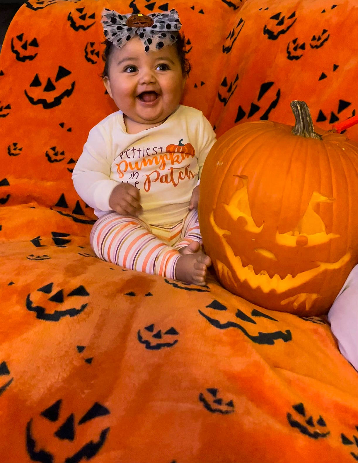 Layla joined the competition — help win amazing prizes! baby_toddler_clothing, calabaza, face, facial_expression, gourd, happy, headwear, human_body, leaf, orange, people, people_in_nature, person, photograph, plant, pumpkin, smile, squash, toddler, white