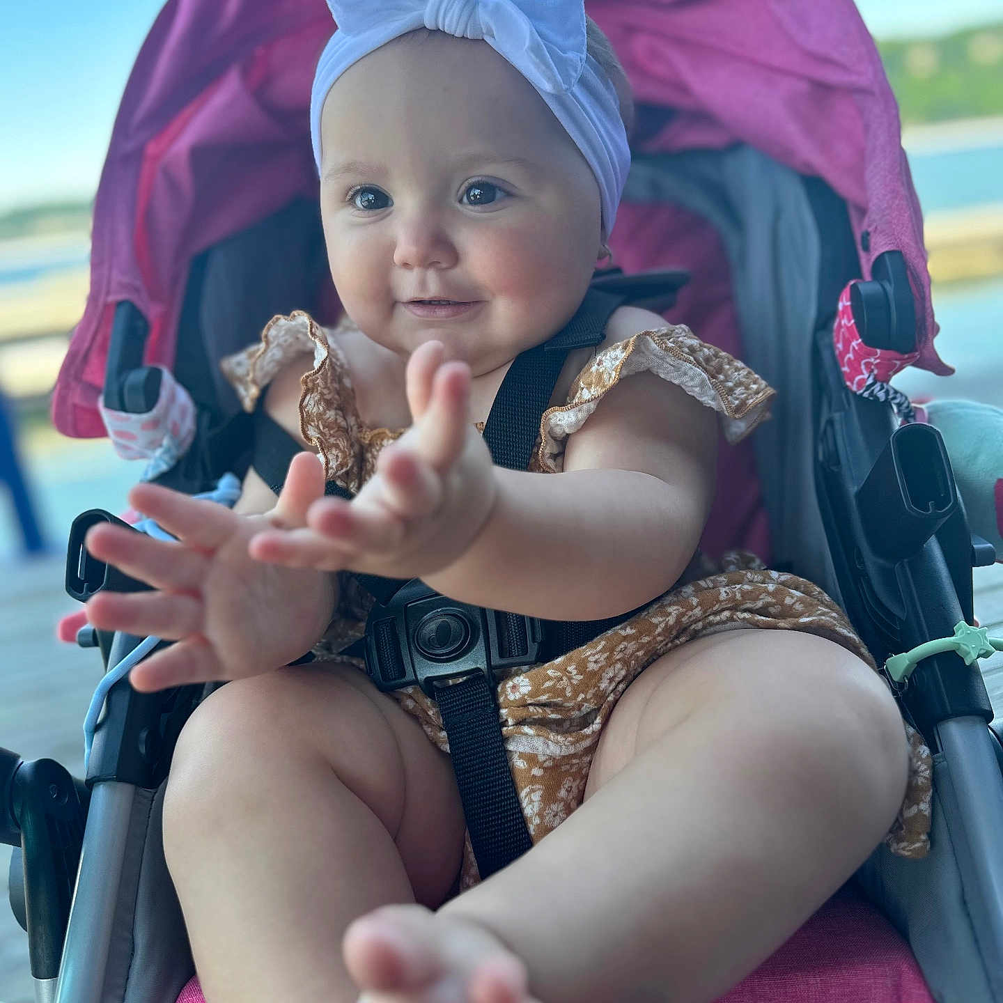 Milani is registered to the contest to win money with this photo: accessories, baby, bodypart, cap, clothing, dress, face, finger, glove, hand, happy, hat, head, outdoors, person, photography, portrait, smile, stroller, sunglasses