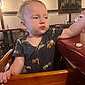 Apolo is registered to the contest to win money with this photo: child, toddler, baby, restaurant, high_chair, table, wooden_furniture, indoor, portrait, face, blond_hair, curious, sitting, reaching, shirt, vehicle_pattern, food, crumb, dining, photography