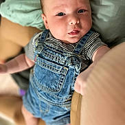 Apolo joined the competition — help win amazing prizes! baby, denim_overalls, striped_shirt, infant, face, eyes, hand, arm, skin, person, cute, child, young, portrait, indoor, clothing, sitting, expression, looking_up, cozy