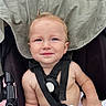 Apolo is registered to the contest to win money with this photo: baby, child, infant, stroller, seated, smiling, face, portrait, outdoor, harness, safety_strap, blonde_hair, blue_eyes, bare_chested, diaper, wipe, fabric, canopy, wheel, happy