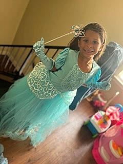 Zaniyah is registered to the contest to win money with this photo: child, embellishment, event, fashion_accessory, fashion_design, formal_wear, fun, happy, headpiece, human_leg, jewellery, joy, magenta, peach, person, room, sitting, sleeve, smile, textile