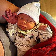 Anderson a rejoint le concours — aidez-le/la à gagner de superbes lots ! newborn, baby, sleeping, sweater, hat, blanket, red_blanket, person, arm, cozy, indoors, child, infant, cute, peaceful, resting, holiday, warm, knitwear, portrait