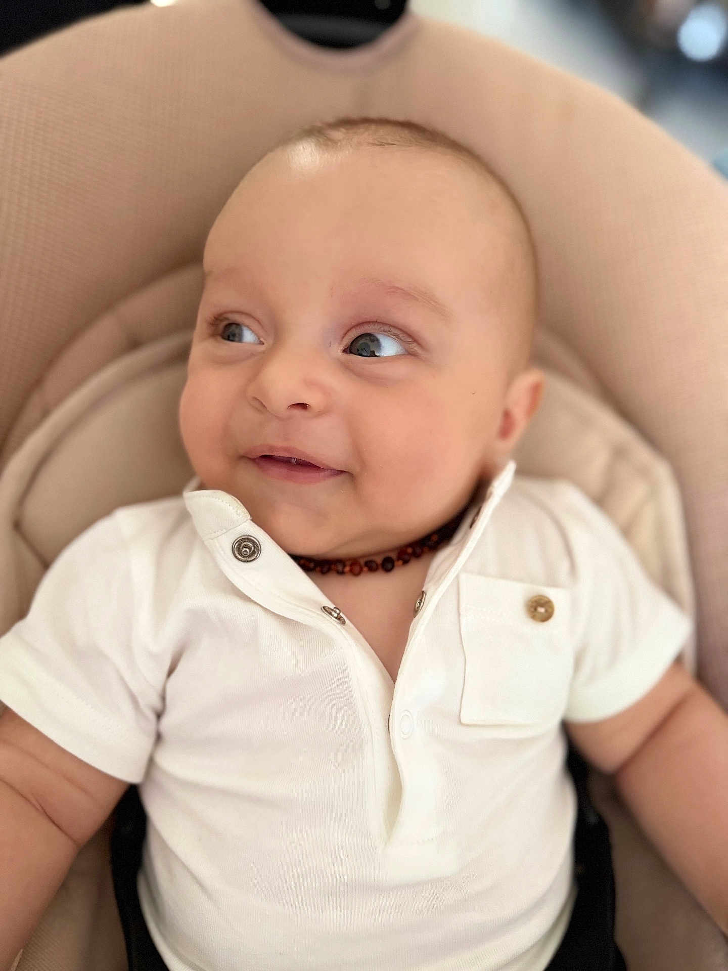 Sohan participe au concours pour gagner de l'argent avec cette photo : baby, infant, child, white_shirt, beige_cushion, portrait, smile, face, cute, young, seated, indoor, soft_lighting, necklace, happy, closeup, skin, expression, person, casual_clothing