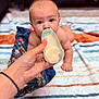 baby, blanket, bottle, care, comfort, crawling, cute, eyes, face, feeding, focus, hand, indoor, infant, mouth, nurturing, person, skin, striped_blanket, young_child