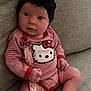 baby, infant, child, headband, flower, onesie, hello_kitty, pacifier, clip, socks, couch, sofa, fabric, striped_clothing, cute, sitting, indoors, portrait, soft_lighting, curious