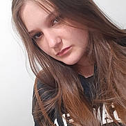 Gabriella participe au concours pour gagner de l'argent avec cette photo : girl, young_person, long_hair, brown_hair, casual_clothing, black_shirt, portrait, indoor, white_background, face, head, person, youth, candid, natural_light, expression, looking_away, human, tshirt, hair
