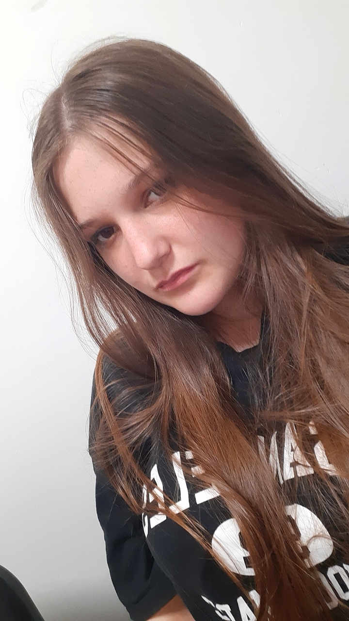Gabriella participe au concours pour gagner de l'argent avec cette photo : girl, young_person, long_hair, brown_hair, casual_clothing, black_shirt, portrait, indoor, white_background, face, head, person, youth, candid, natural_light, expression, looking_away, human, tshirt, hair