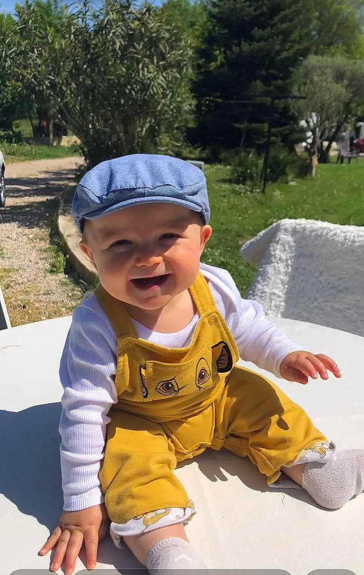 Myles a rejoint le concours — aidez-le/la à gagner de superbes lots ! baby, baby_toddler_clothing, baseball_cap, cap, child, costume, fashion_accessory, fun, grass, happy, hat, headwear, joy, leisure, person, personal_protective_equipment, plant, recreation, sitting, sleeve