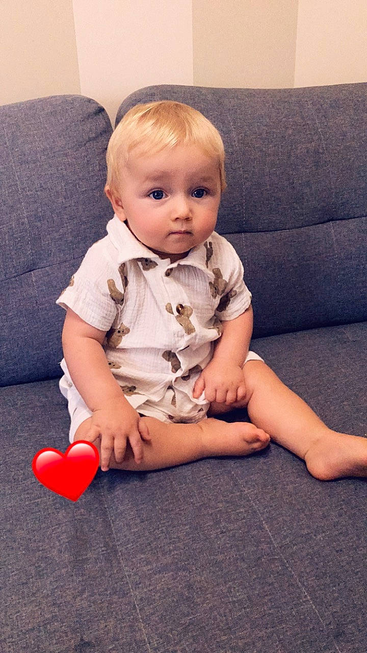 Myles participe au concours pour gagner de l'argent avec cette photo : arm, baby, baby_toddler_clothing, cheek, chin, comfort, couch, eye, facial_expression, finger, floor, flooring, joint, knee, leg, person, shoulder, skin, sleeve, standing