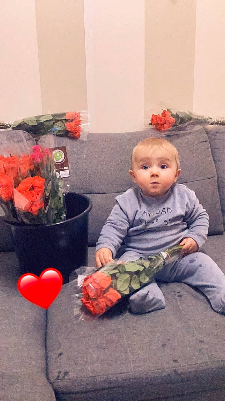 Myles participe au concours pour gagner de l'argent avec cette photo : annual_plant, artificial_flower, baby, beauty, carmine, child, cut_flowers, flooring, floral_design, flower, flower_arranging, houseplant, orange, peach, person, petal, plant, red, room, sitting